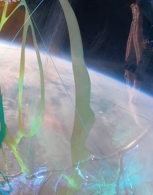BEYOND EARTH (artist collective) with RICHELLE ELLIS, Living Light, 2021, steel frame, AI-generated forms on laser-cut vinyl, iridescent PVC, clear PVC, laser-cut foam floats, glow-in-the-dark tape, suspended by a 50-foot Stratollite balloon at 120,000 feet above Earth, dimensions variable. Credit: Space Perspective / Beyond Earth.