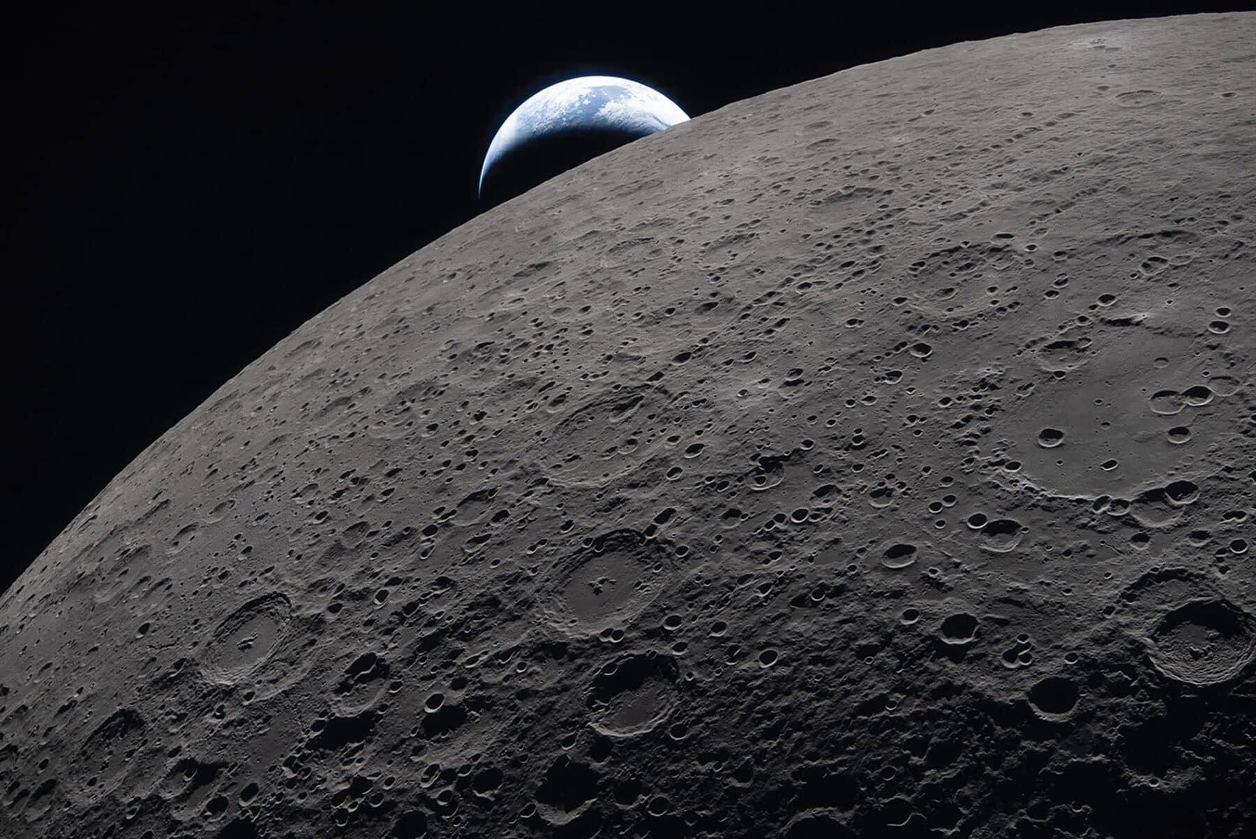 Artemis II astronauts captured this view of Earth setting beyond the lunar horizon on April 6, 2026, moments before their spacecraft passed behind the Moon and lost contact with Earth for 40 minutes. Ohm crater appears in the foreground. Image credit: NASA.